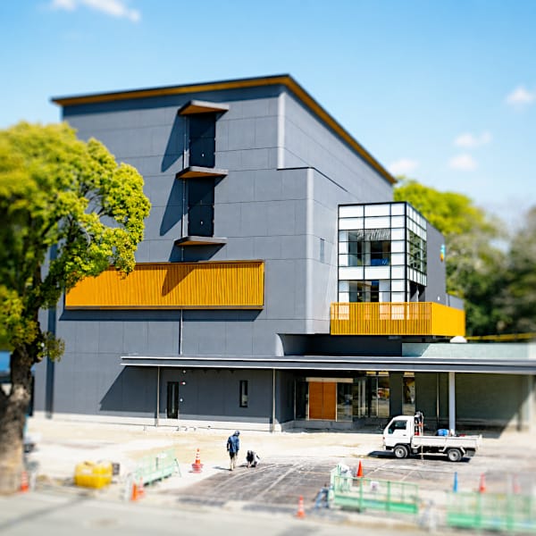 グレーとオレンジのアクセントが特徴的な鉄骨造の事業所建築