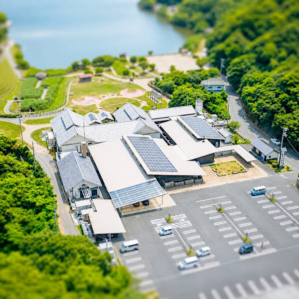 太陽光パネルを備えた複合施設と緑地公園の航空写真